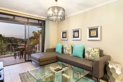 a living room with a couch and a glass table at Waterstone East F201 in Cape Town