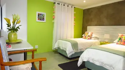 a bedroom with two beds and green walls at Sonvanger 2 in Paarl