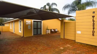 a yellow house with a black roof and a patio at Sonvanger 2 in Paarl