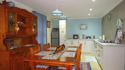 a kitchen with a wooden table and a table and chairs at Sonvanger 2 in Paarl