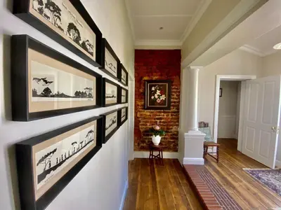 a hallway with black and white pictures on a wall at Banhoek Corner Guesthouse in Stellenbosch