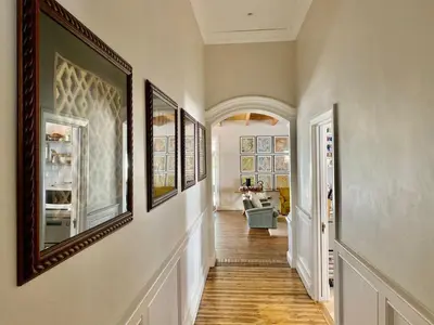 a hallway with paintings on the walls of a home at Banhoek Corner Guesthouse in Stellenbosch