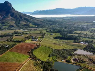 an aerial view of a valley with a lake and mountains at Banhoek Corner Guesthouse in Stellenbosch