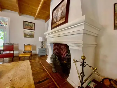 a living room with a fireplace in a house at Banhoek Corner Guesthouse in Stellenbosch