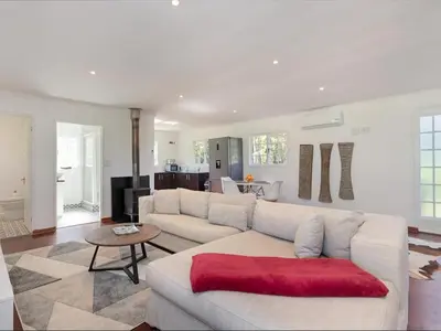 a living room with a white couch and a red blanket at La Ferme Guest Farm - Hot Tubs in Franschhoek