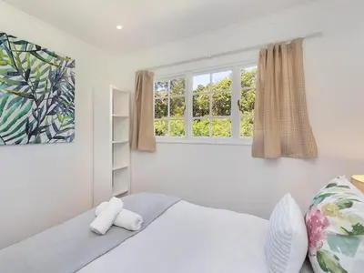 a bedroom with a bed and two windows at La Ferme Guest Farm - Hot Tubs in Franschhoek