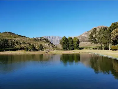 a large body of water with mountains in the background at La Ferme Guest Farm - Hot Tubs in Franschhoek