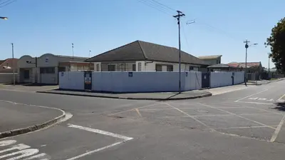 an empty street with a white fence in front of a house at MJ ACCOMODATION in Cape Town