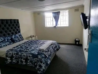 a bedroom with a bed and a window at MJ ACCOMODATION in Cape Town