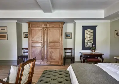 a bedroom with a wooden door and a table at Deux Frères Wine Estate & Luxury Villas in Stellenbosch