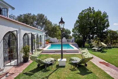 a house with a pool and two chairs and a street light at Deux Frères Wine Estate & Luxury Villas in Stellenbosch