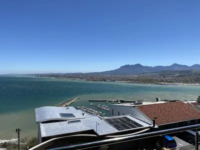 a building with solar panels on it next to a body of water at Perhethian in Cape Town