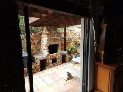 a cat is sitting in front of a stone fireplace at Perhethian in Cape Town