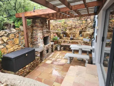 an outdoor patio with a stone wall and benches at Perhethian in Cape Town