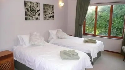 two beds in a hotel room with towels on them at Jocks Place (on the sea) in Bettyʼs Bay