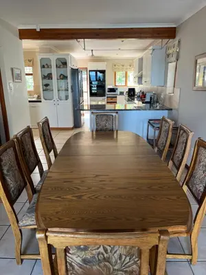 a dining room table with chairs and a kitchen at Jocks Place (on the sea) in Bettyʼs Bay