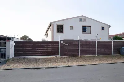 a house behind a fence in front of a house at 20 On Percy in Cape Town