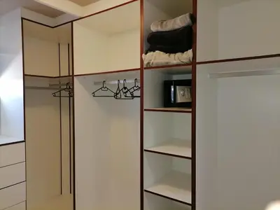 a walk in closet with white cabinets and a glass door at 20 On Percy in Cape Town