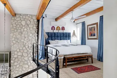 a bedroom with a king sized bed and a staircase at No. 2 The Yard in Franschhoek