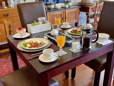 a table with plates of food and drinks on it at Mountainview Guesthouse in Cape Town