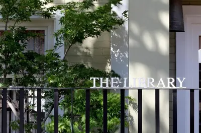 a sign on a fence in front of a building at The Library in Franschhoek