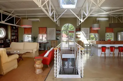 a living room with red chairs and a staircase at The Library in Franschhoek