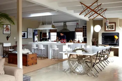 a kitchen and living room with a table and a counter at Explorers Club in Franschhoek