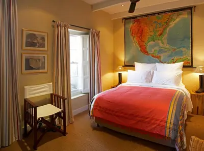 a bedroom with a bed with a map on the wall at Explorers Club in Franschhoek