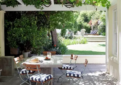 a table and chairs on a patio with a garden at Tugela in Franschhoek