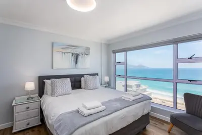 a bedroom with a bed with a view of the ocean at Ocean View A1101 by CTHA in Bloubergstrand