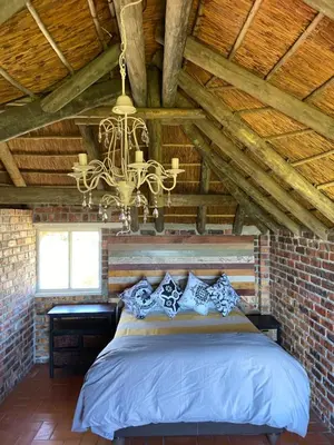 a bedroom with a bed and a chandelier at Hemel in Hermanus Three bedroom Home in Hermanus