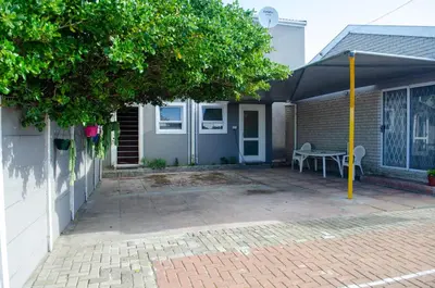 a house with a patio with a table under a canopy at Birds Holiday Accommodation 2 in Cape Town