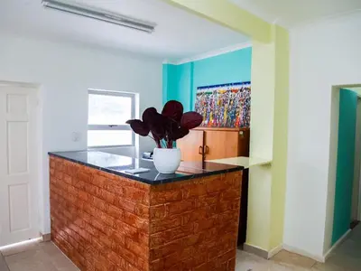a room with a vase with a plant on a counter at Relaxing Guest House in the Heart of Ndabeni in Cape Town