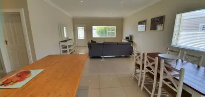 a living room with a wooden table and a couch at 147 Abalone-Inn in Hermanus