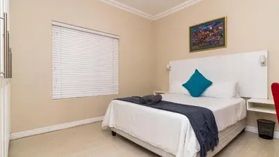 a bedroom with a bed with a blue pillow at 147 Abalone-Inn in Hermanus
