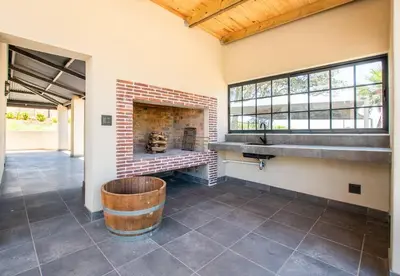 a room with a brick fireplace and a wooden barrel at Eikenhof Estate in Brackenfell