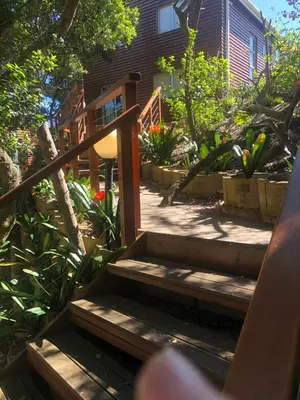 a wooden staircase leading to a house with flowers at Little Haven 10 & 12 in Hermanus