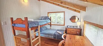 a small room with a bunk bed and a table at Little Haven 10 & 12 in Hermanus