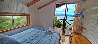 a bedroom with a blue bed and a large window at Little Haven 10 & 12 in Hermanus