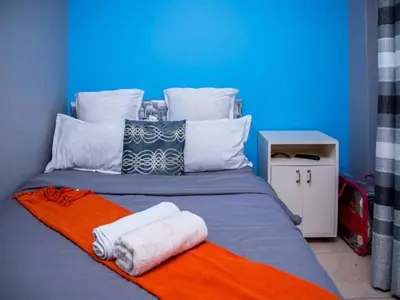 a bed with two towels on top of it at Relaxing guest House in the heart of Ndabeni in Cape Town