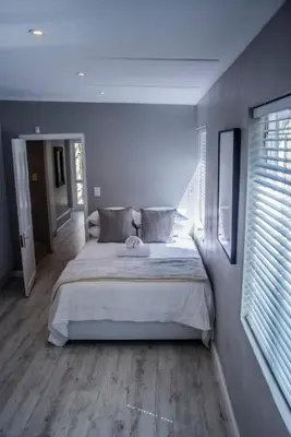 a bedroom with a large bed and a window at Seven on Flora- Hot Tub, Modern with amazing outside area in Hermanus