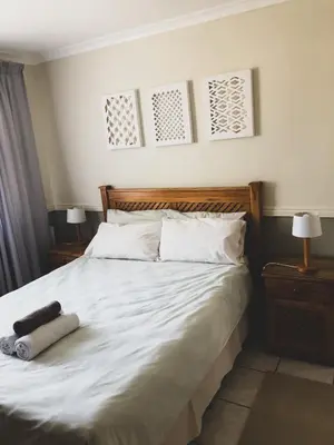 a bedroom with a large white bed with two night stands at The Bohemian Guesthouse in Cape Town