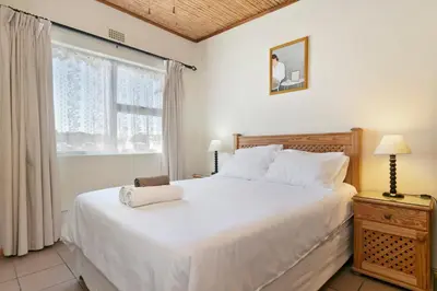 a bedroom with a large white bed and a window at The Bohemian Guesthouse in Cape Town