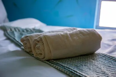 a rolled up towel sitting on top of a bed at Relaxing Guest House in the heart of Ndabeni in Cape Town