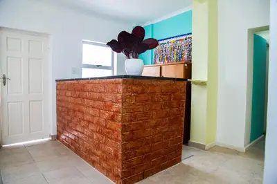 a room with a brick wall with a vase on it at Relaxing Guest House in the heart of Ndabeni in Cape Town