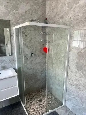 a shower with a glass door in a bathroom at izuba Lodge in Cape Town
