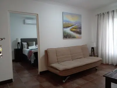 a living room with a couch and a bed at Sikelela Guest House in Cape Town