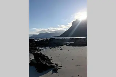 a view of a mountain with the sun shining at Rooi Els Sea Cottage in Rooiels
