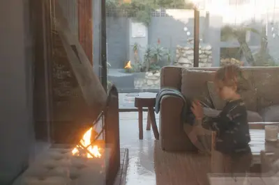 a little girl sitting on a couch in a living room at Rooi Els Sea Cottage in Rooiels