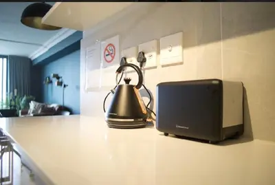 a tea kettle sitting on a counter next to a printer at Rose Gold @The Winchester in Cape Town